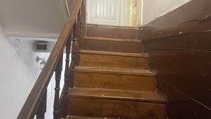 A wooden staircase with a handrail leading to a white door. - Dora (Bakar)