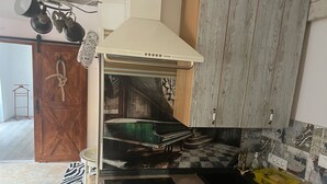 A kitchen with a vintage stove, wooden cabinets, and a checkered backsplash. - Dora (Bakar)