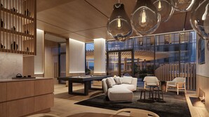 Ein modernes Interieur mit Billardtisch, Sitzgelegenheit und großen Fenstern mit Blick auf die Stadt.