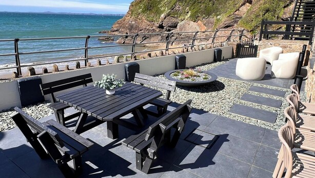 A patio with outdoor seating, a fire pit, and a view of the sea. - Graftons, Little Haven (Little Haven)