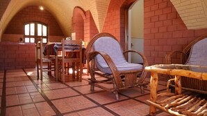 A cozy room with brick walls, wooden furniture, and a tiled floor.