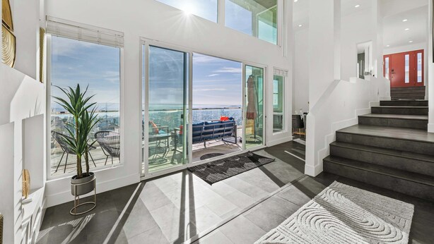 A spacious interior with large windows, a staircase, and a view of the city. - 5000sf Luxury 5BR, Hot Tub, Panoramic Views, Games, Fire Pit (Spring Valley)