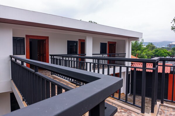 A modern building with a balcony, a staircase, and a view of the surrounding area.