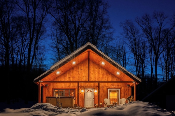 Charming cabin glowing warmly at night—inviting you to slow down, settle in, and simply breathe.