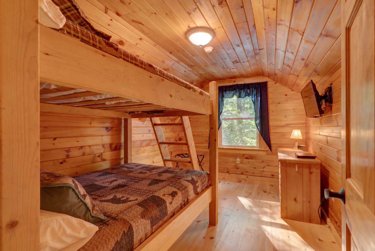 Bunk room, offering plenty of space and warm cabin charm.