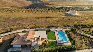Eine Villa mit Swimmingpool, terrassenförmig angelegten Weinbergen und Meerblick.