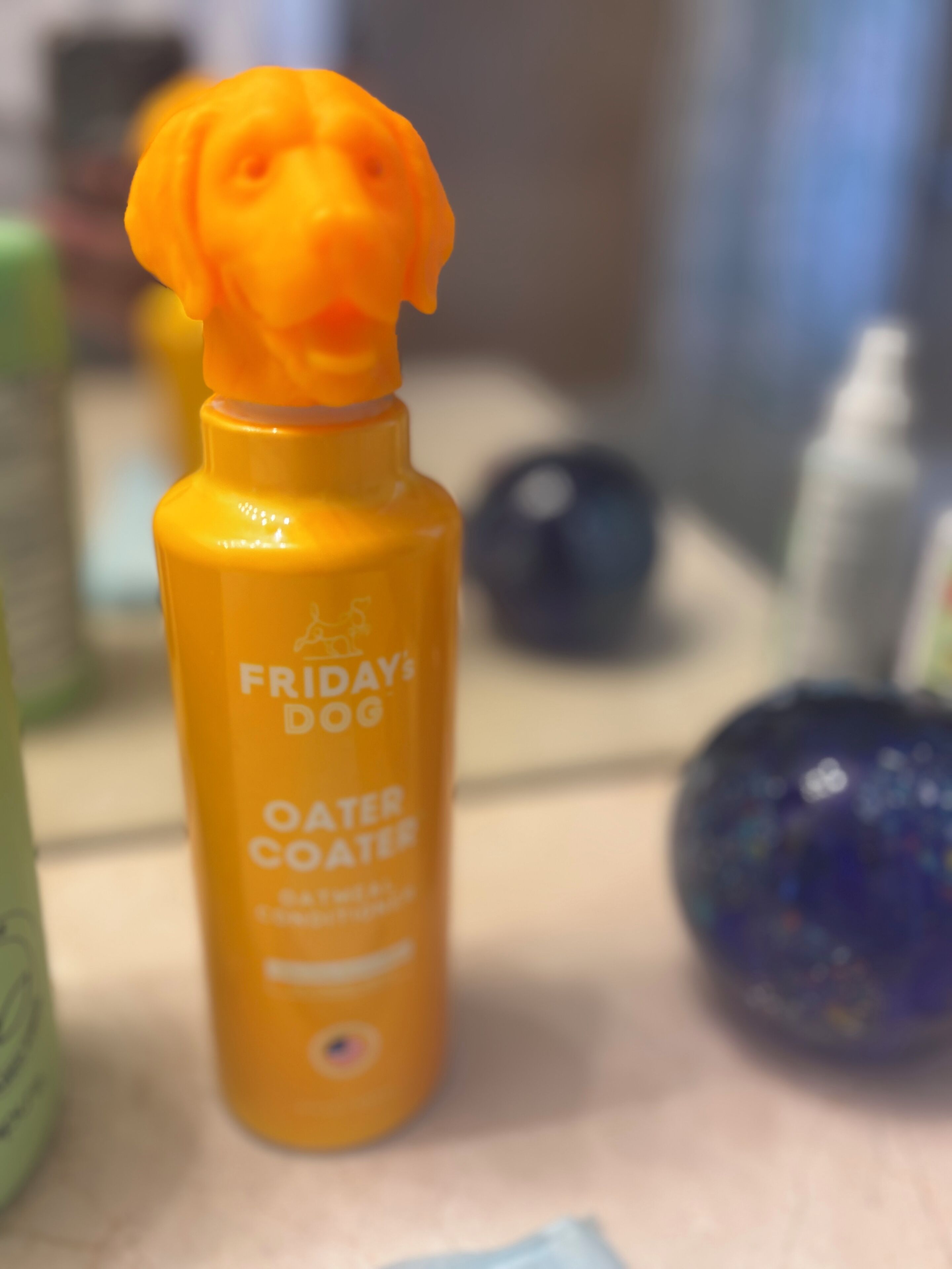 A bottle of Oater Coater with a dog-shaped cap, labeled 'FRIDAYS DOG'.