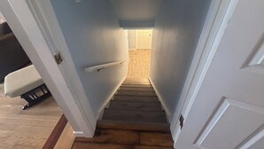 A narrow stairway with a wooden floor and white walls. - Cozy Calgary Stampede Sanctuary Home (Calgary)
