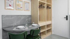 A dining area with a marble table, green chairs, and a wooden shelving unit. - Nice Godrop Campeche (Florianópolis)