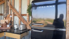 Cozinha com geladeira Galanz, liquidificador, torradeira e utensílios de madeira em uma bancada.