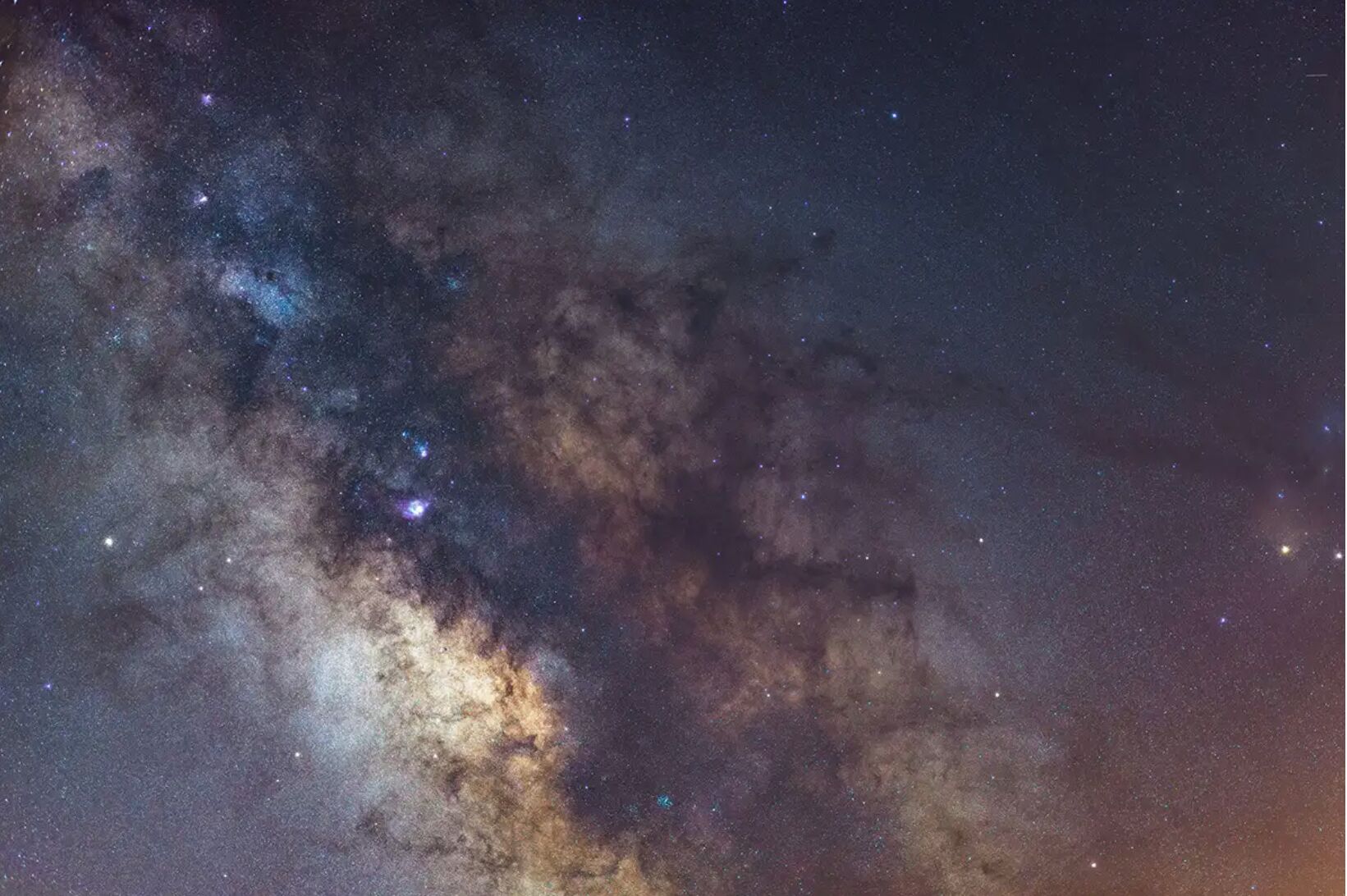 A night sky with stars and a visible galaxy.