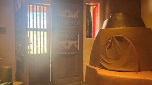A cozy living room with a sofa, a wooden coffee table, and a patterned rug. - Cozy Private Adobe Studio • Kiva Fireplace • Walk to Taos Plaza • Pet-Friendly (Taos)