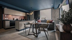 A modern kitchen with a central island, a dining area with a round table and chairs, and a living area with a sofa and cushions. - Indigo Veracruz Roma norte Apt 1B I 1B (Mexico City)