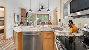 A modern kitchen with a central island, stainless steel appliances, and pendant lighting. - Sm8272-2 (Keystone)