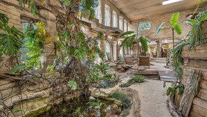 Ein Innenhof mit Wasserspiel, Steinwänden und unterschiedlicher Bepflanzung.