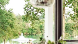 Un comedor con vista a un lago y una fuente.