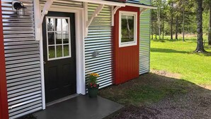 A house with a black door, a small porch, and a window. - Private Blue Pine Getaway (Duluth)