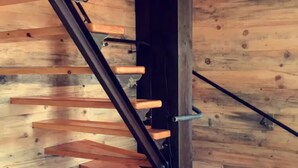 A wooden staircase with black metal railings and wooden steps. - Private Blue Pine Getaway (Duluth)