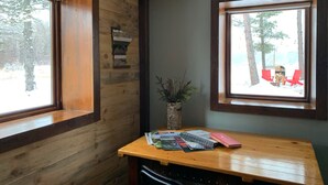 A wooden cabin room with two windows, a wooden desk, and a small plant. - Private Blue Pine Getaway (Duluth)