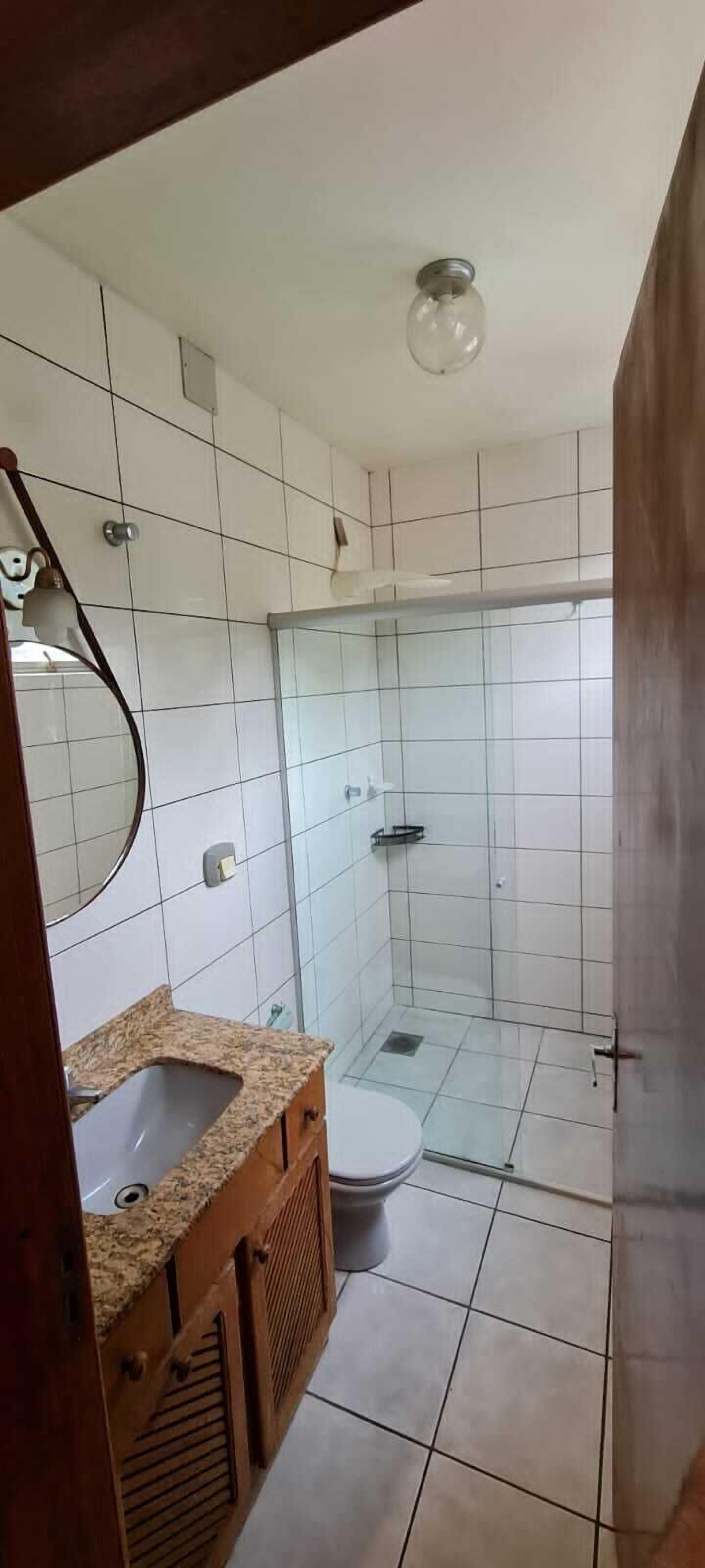 A bathroom with a shower, toilet, and sink.