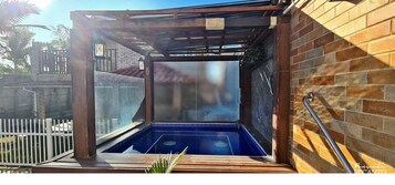 Una piscina al aire libre, sillones reclinables de piscina