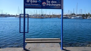 Un panneau d’affichage avec du texte en français et en anglais, indiquant un circuit touristique et la présence d’un service de navettes fluviales.