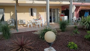 Une cour dotée d’un espace extérieur aménagé avec des sièges, d’un élément décoratif aquatique et d’un bâtiment pourvu d’un balcon.