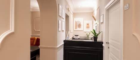 A hallway with a black reception desk, framed artwork on the walls, and a door labeled "ROOM 304".