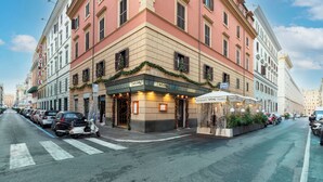 A hotel with a classic European facade, a ground-floor restaurant, and a pedestrian crossing. - HOTEL MAGIC (Rome)