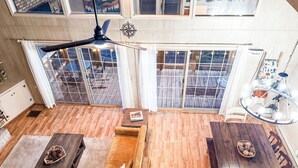 A spacious living area with a wooden floor, a sofa, a dining table, and a ceiling fan. - "18 Seasons" Seconds to Blue Ridge Parkway, & Mabry Mill. Game room w/Bar (Hillsville)