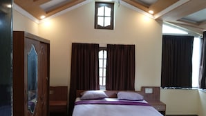 Een slaapkamer met een bed, een houten garderobe en een raam met gordijnen.