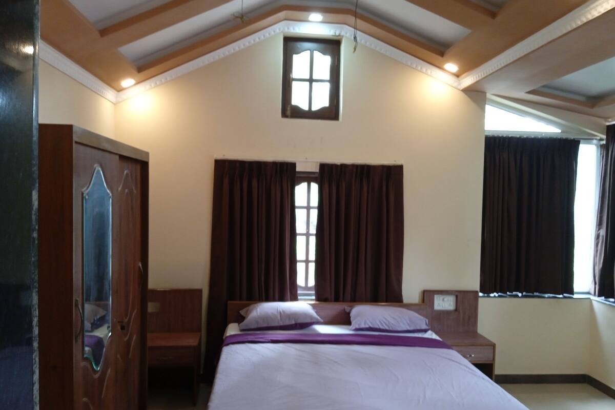 Ein Schlafzimmer mit Bett, Holzschrank und einem Vorhangfenster.