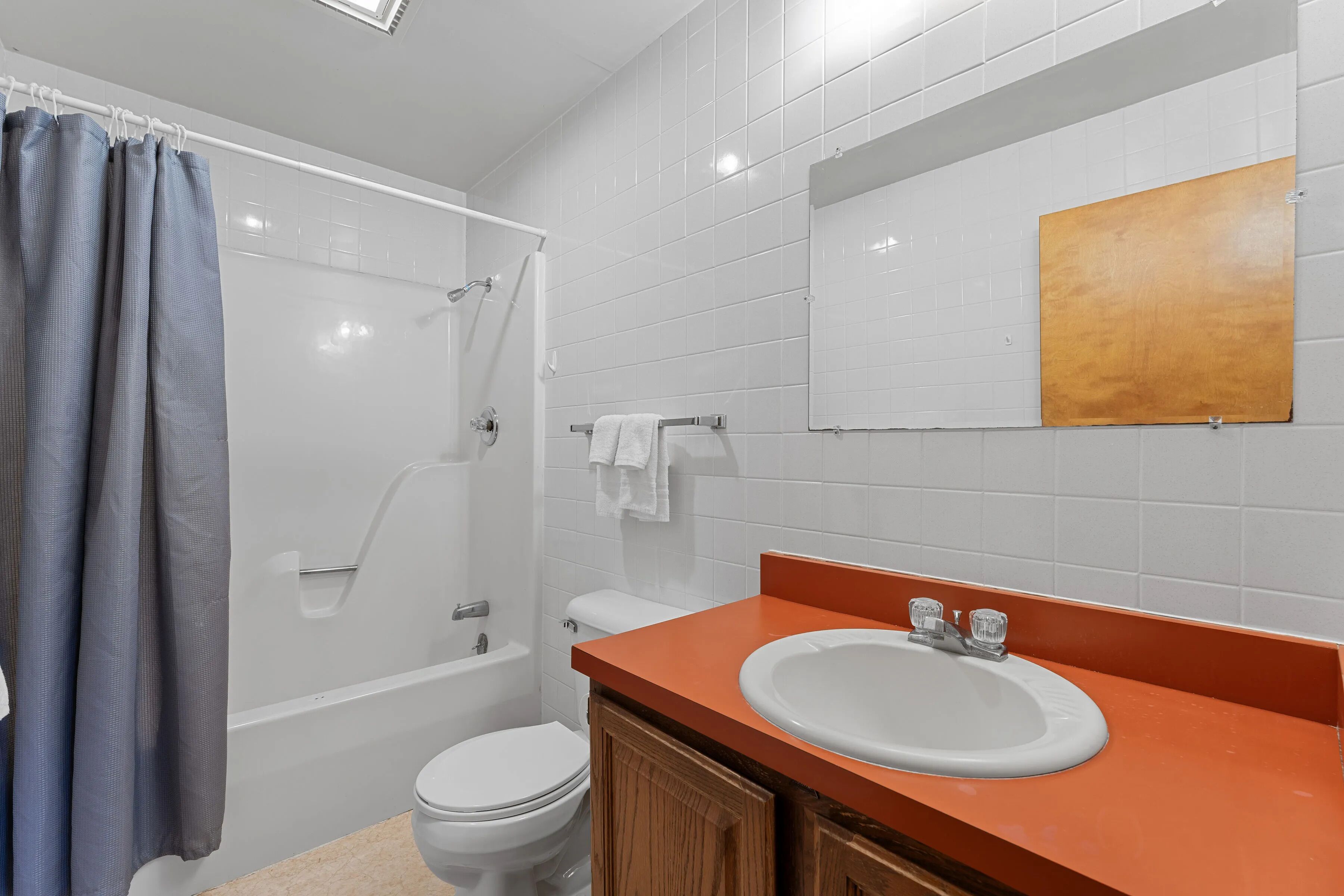 A bathroom with a shower, toilet, and sink.