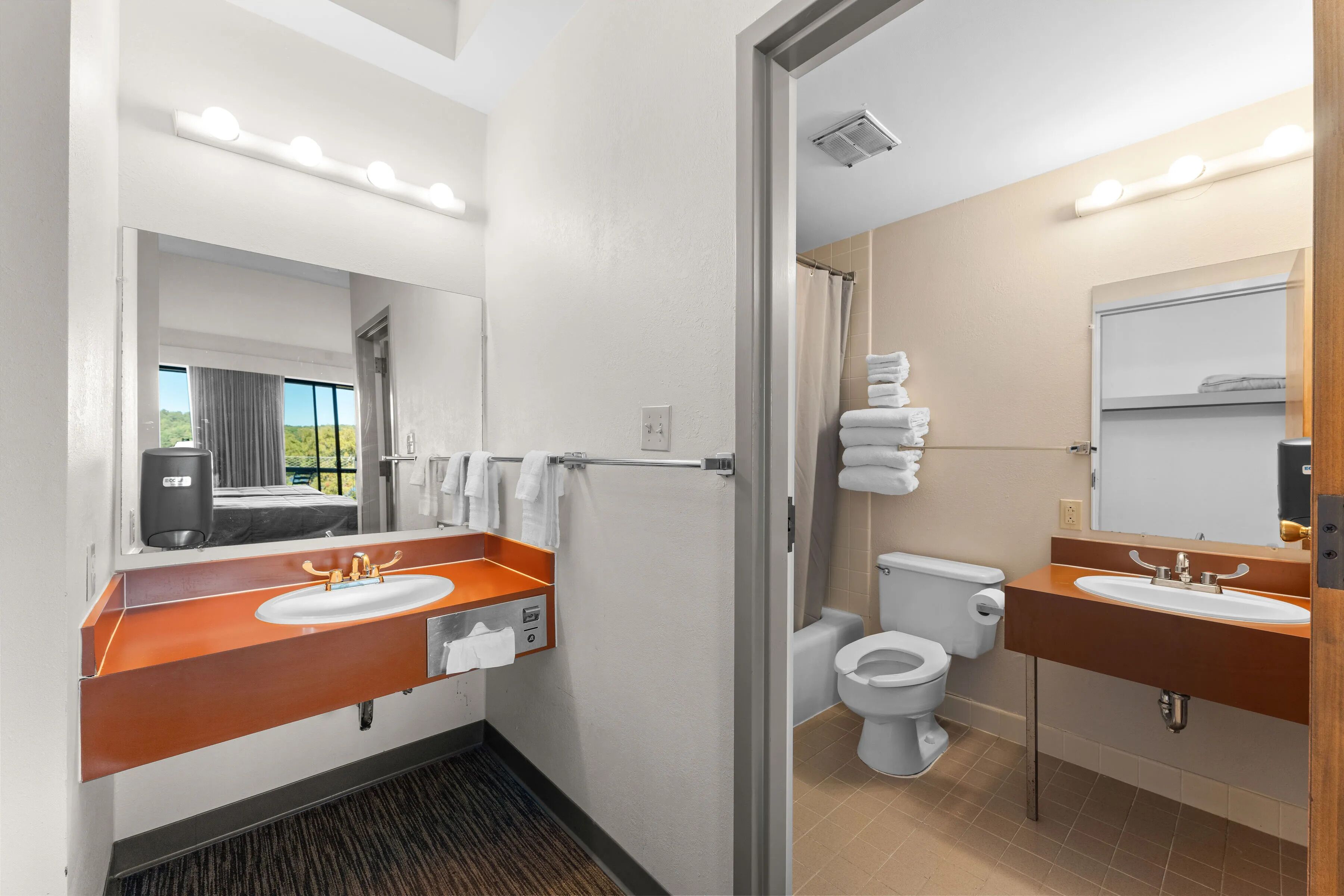 A modern bathroom with two sinks, a shower, and a toilet.