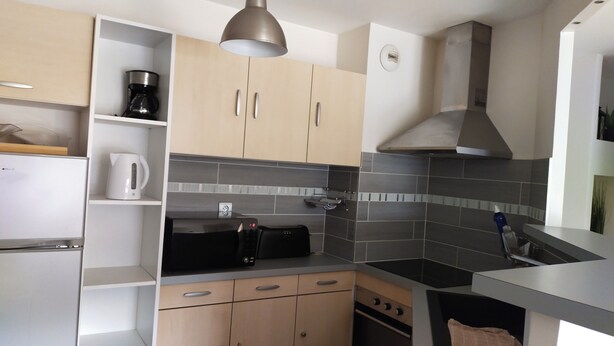 A modern kitchen with a built-in oven, a coffee maker, and a toaster. - 3-room 2-bedroom apartment close to the ramparts of Vannes (Vannes)