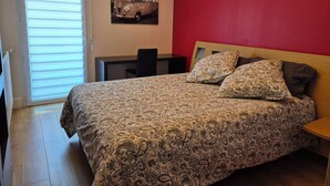 A bedroom with a bed, a desk, a chair, and a window with blinds. - 3-room 2-bedroom apartment close to the ramparts of Vannes (Vannes)