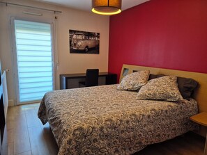 A bedroom with a bed, a desk, a chair, and a window with blinds. - 3-room 2-bedroom apartment close to the ramparts of Vannes (Vannes)