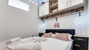 A bedroom with a bed, bedside tables, a wardrobe, and a hanging light fixture. - Antigona (Bakar)