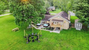 Une maison dotée d’un grand jardin, d’un jacuzzi et d’une terrasse couverte.