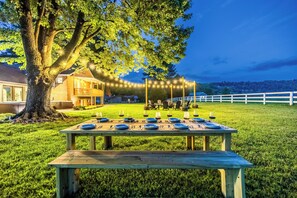 A wooden picnic table set up outdoors with blue plates and cutlery. - 4mi to Buffalo Trace, Hot Tubs, Gameroom, Firepit (Frankfort)