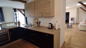 Une cuisine moderne avec des meubles en bois, un four encastré et une grande fenêtre.