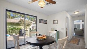 A dining area with a round table, white chairs, and a ceiling fan. - Pet Friendly, Golf Course 3BR/3BA Home, 549 Remora Drive (Fripp Island)