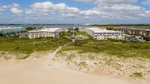A coastal hotel with multiple buildings, a beach, and a clear sky. - A Place at the Beach - 2 bedroom, 2 baths - Pools, Waterslide, Mini-golf & more! (Atlantic Beach)