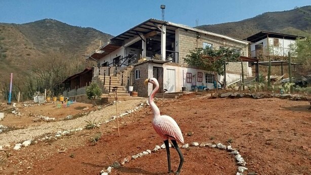 A building with a large open porch and a staircase leading to the entrance. - Paraiso Casa de Playa (Taganga)