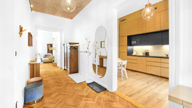 Une cuisine moderne avec des meubles en bois et un micro-ondes noir.