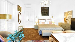 Une chambre à coucher comprenant un lit, des tables de chevet, une commode, une chaise, une lampe, un miroir et un tableau accroché au mur.