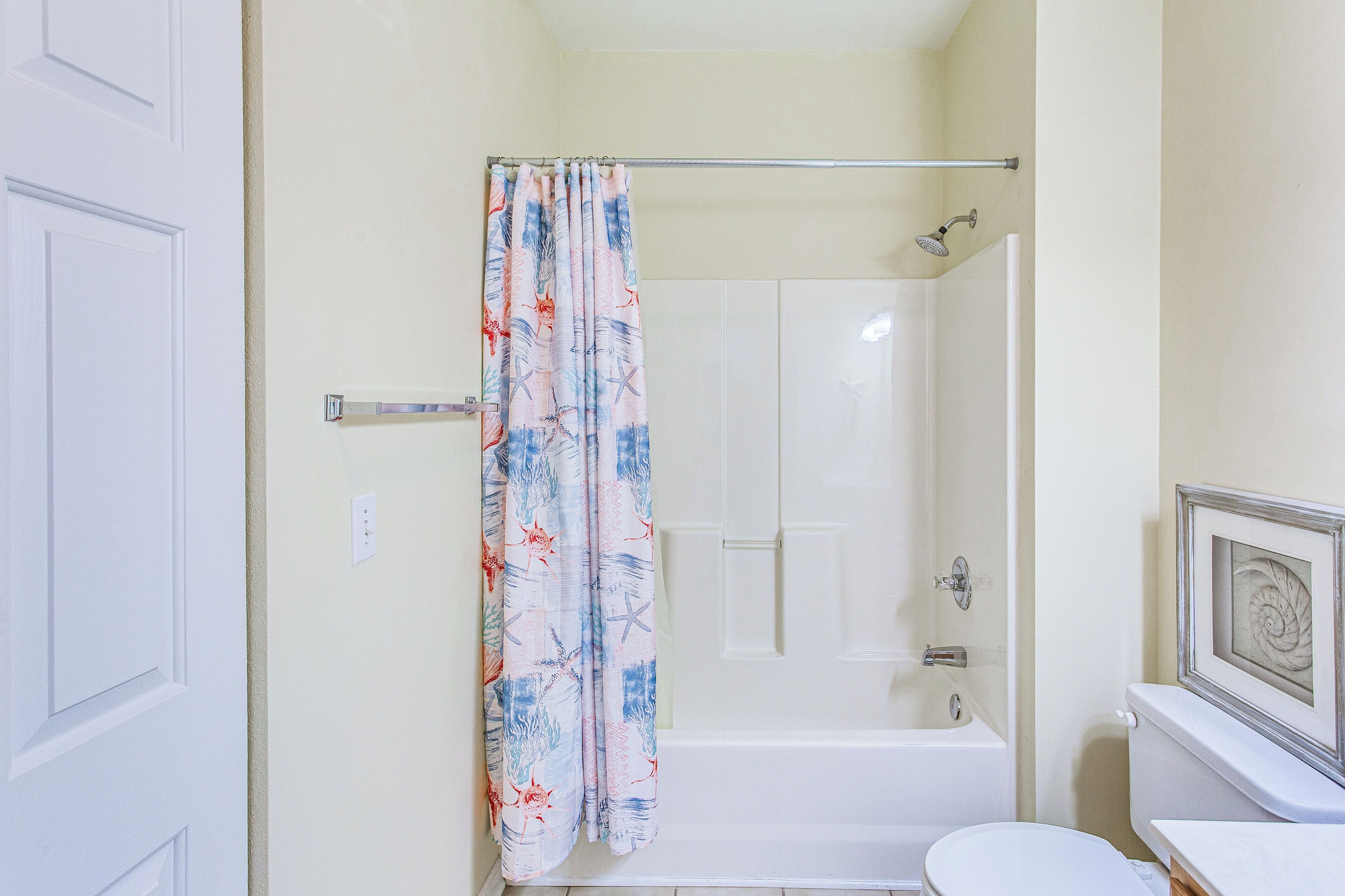 A bathroom with a shower, toilet, and bathtub.