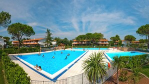 Una amplia piscina al aire libre rodeada de exuberante vegetación y edificios residenciales.