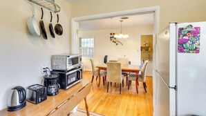 A kitchen with a microwave, toaster, and coffee maker on the counter, a dining table with chairs, and a refrigerator with a colorful magnet. - 4 Mi to FSU! Family Gem w/ Deck in Tallahassee (Tallahassee)