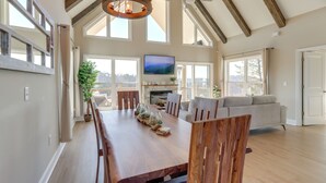 Un comedor amplio con una mesa y sillas de madera, una chimenea y un televisor.